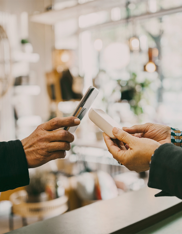 Kunde bezahlt in einem Geschäft seinen Einkauf mit dem Smartphone